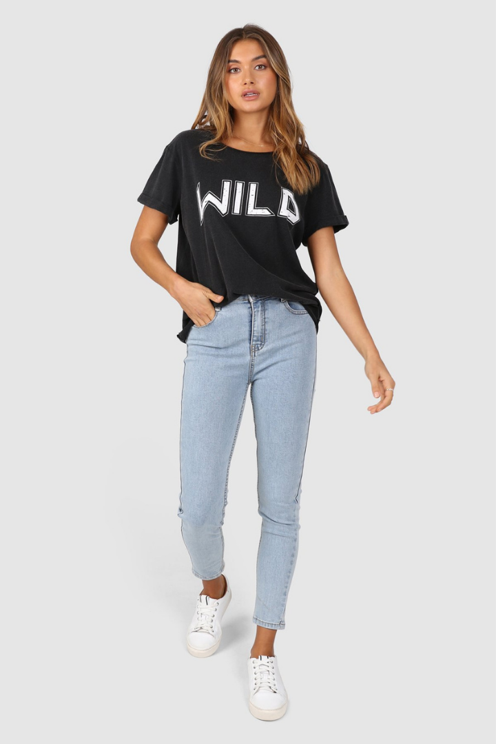 Bailage Caucasian Female wearing Vintage  Casual  Basic  WILD Graphic Tee  Short Sleeved T-Shirt  Relaxed Fit  Round Neck paired with high waisted light washed denim jeans and white sneakers