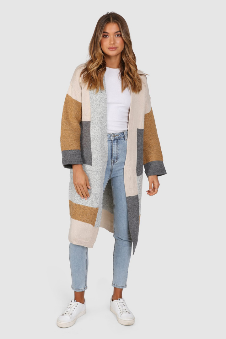 Bailage Caucasian female wearing Oversized Open Front  Multi-Color  Two Sided Pockets  Mid-Length  Relaxed Fit  Color Blocking Pattern  Ribbed Hemline and Details  Relaxed Fit  Casual Cardigan paired with a scoop neck white tee with high waisted light wash denim jeans and white sneakers