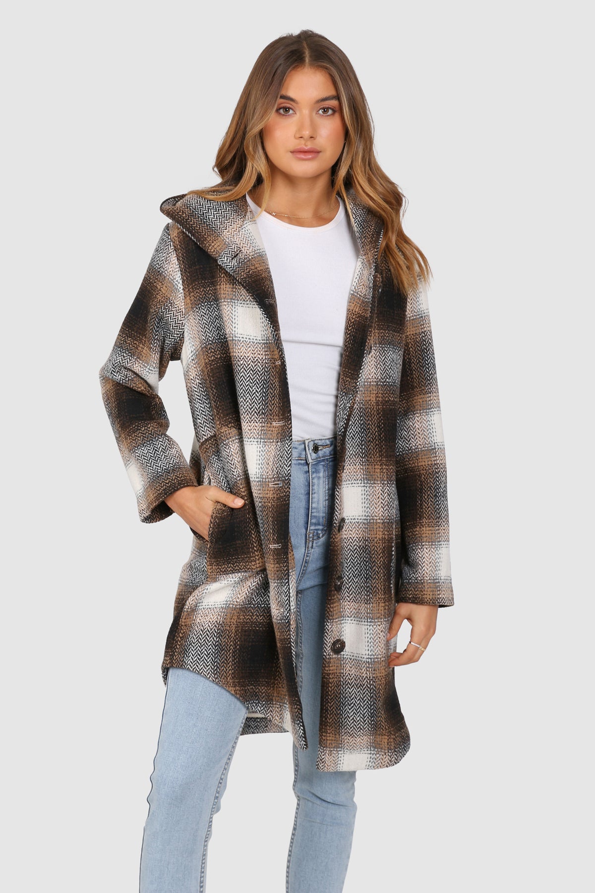 Bailage Haired Caucasian female wearing Plaid Print  Two-oversized front pocket  Relaxed Shoulder  Checkered Lapel Coat  Mid-Length  Buttoned Down  Hooded  Overcoat  Jacket  paired with cotton round neck white tee and high waisted denim jeans