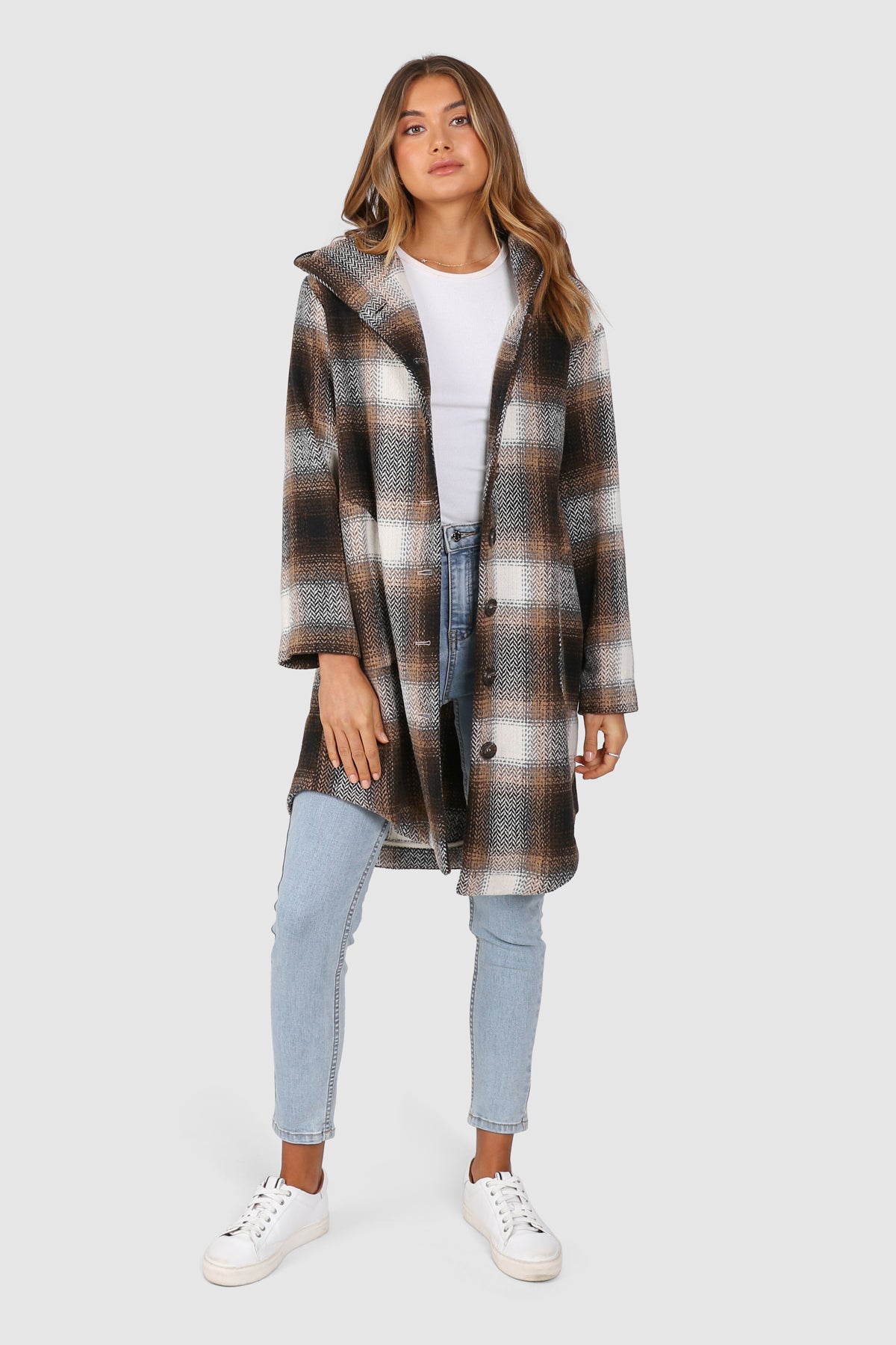 Bailage Haired Caucasian female wearing Plaid Print  Two-oversized front pocket  Relaxed Shoulder  Checkered Lapel Coat  Mid-Length  Buttoned Down  Hooded  Overcoat  Jacket  paired with cotton round neck white tee and high waisted denim jeans and white sneakers 