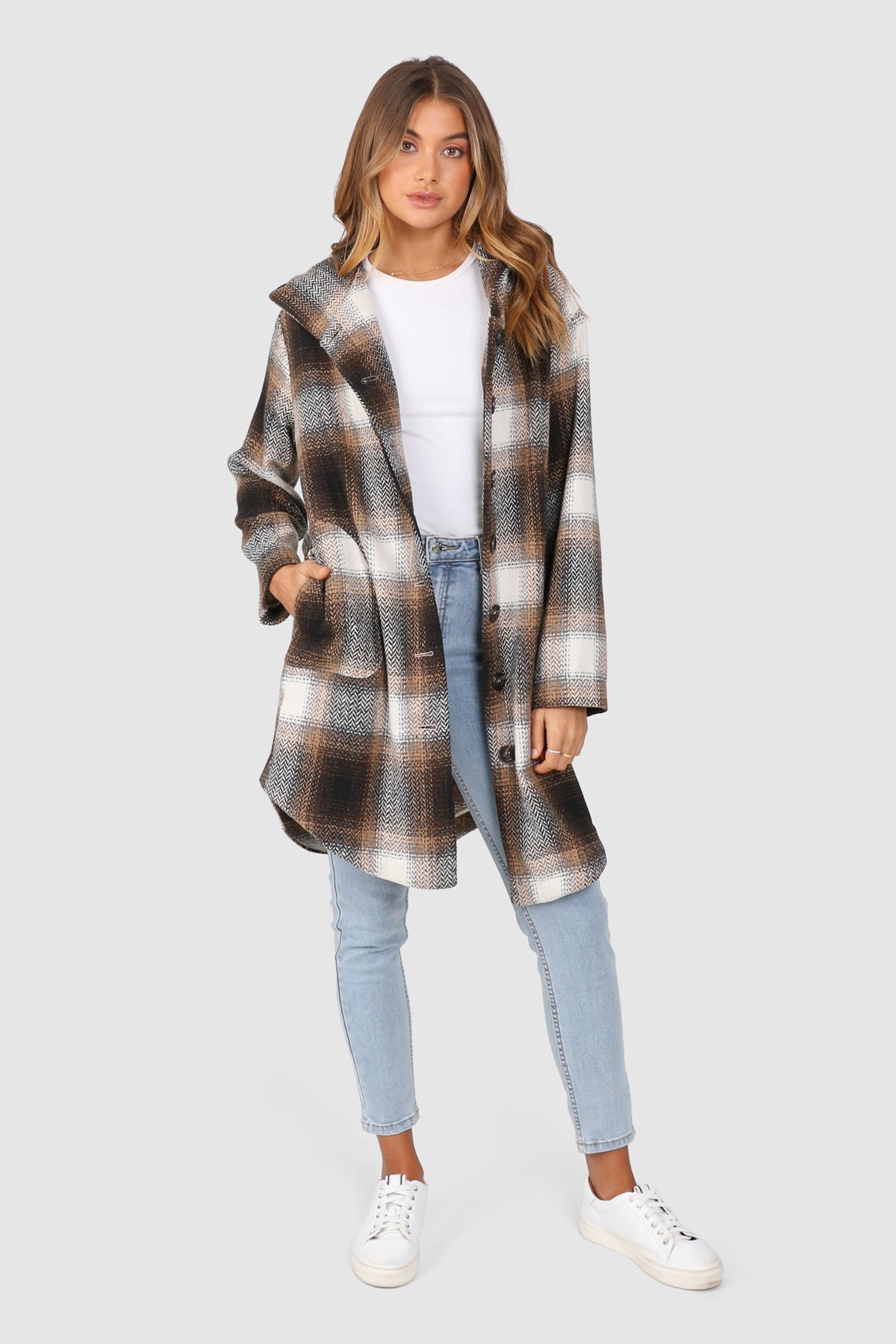 Bailage Haired Caucasian female wearing Plaid Print  Two-oversized front pocket  Relaxed Shoulder  Checkered Lapel Coat  Mid-Length  Buttoned Down  Hooded  Overcoat  Jacket  paired with cotton round neck white tee and high waisted denim jeans and white sneakers 