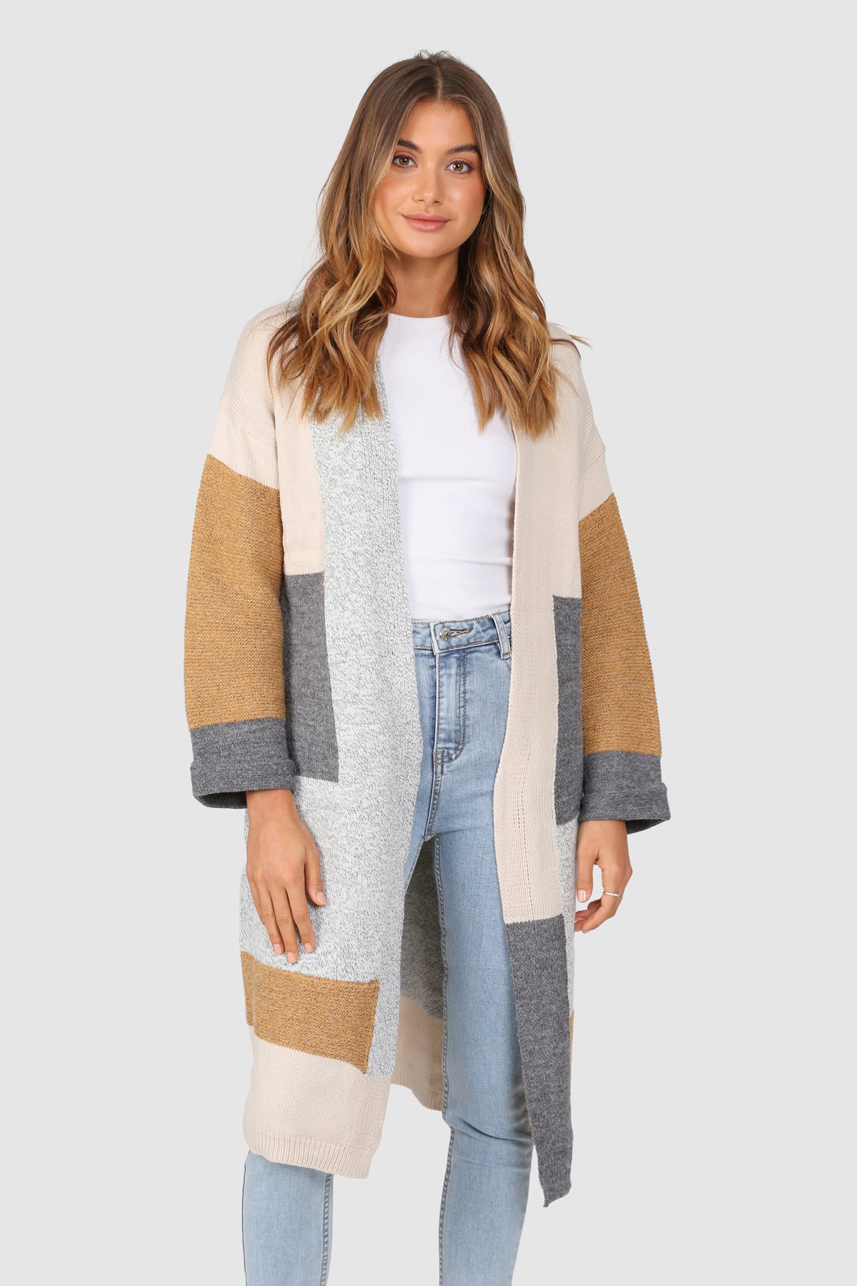 Bailage Caucasian female wearing Oversized Open Front  Multi-Color  Two Sided Pockets  Mid-Length  Relaxed Fit  Color Blocking Pattern  Ribbed Hemline and Details  Relaxed Fit  Casual Cardigan paired with a scoop neck white tee with high waisted light wash denim jeans and white sneakers
