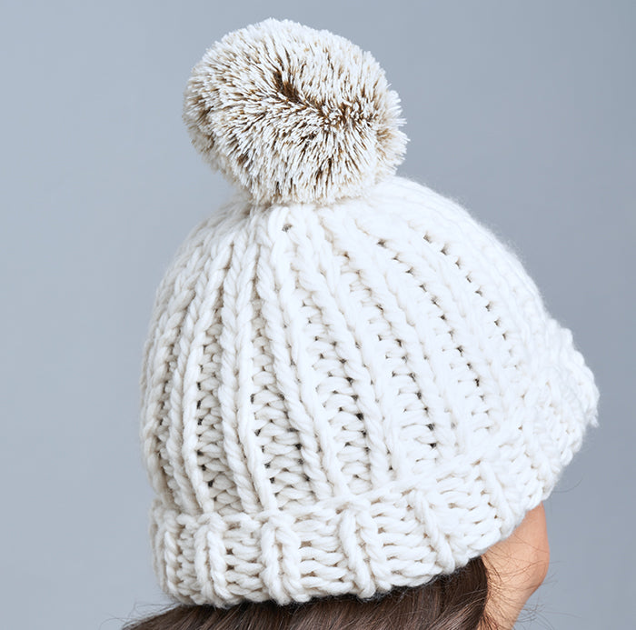 Brunette Caucasian Female wearing Chunky Cable Knit Faux Fur Pom Pom Ribbed Detailed Timeless Winter Accessory Stretchy Toque Easy Slip On Beanie in Ivory