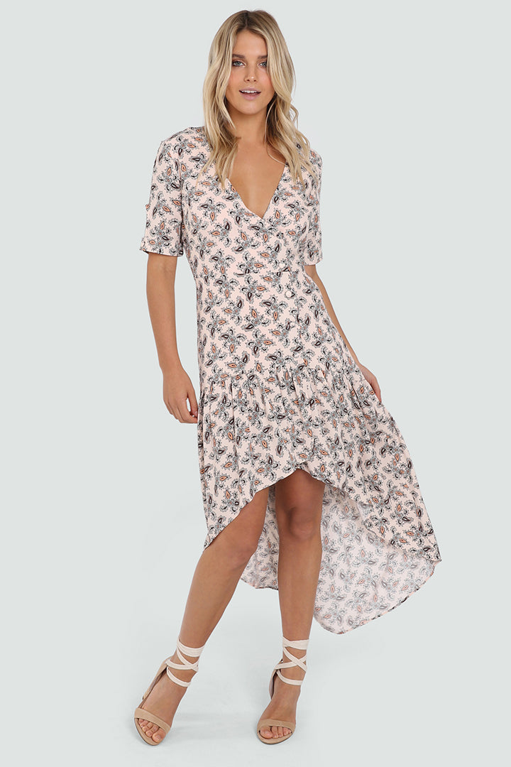 Tall Blonde Caucasian Female wearing a V-Neckline  Ruffled Bottom  Mid-Arm Sleeve  Multi-Colored  Paisley Patterned  Maxi Dress  High Low Spring Dress  Waterfall Bottom Summer Dress Button Details paired with tie up open toe block heels