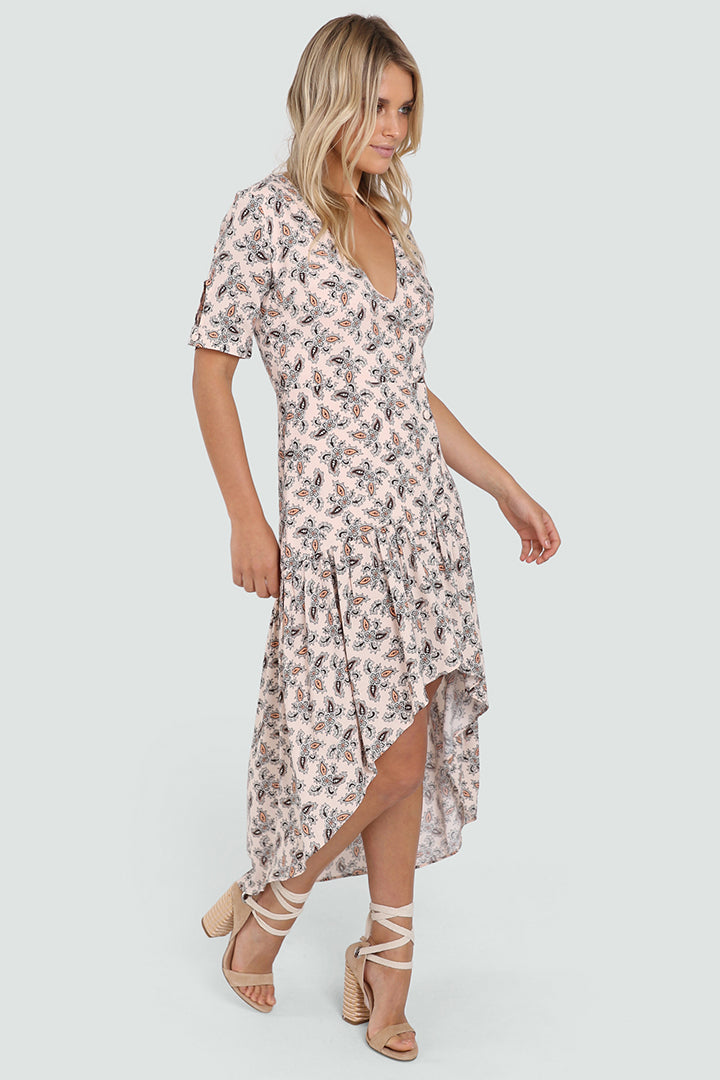 Tall Blonde Caucasian Female wearing a V-Neckline  Ruffled Bottom  Mid-Arm Sleeve  Multi-Colored  Paisley Patterned  Maxi Dress  High Low Spring Dress  Waterfall Bottom Summer Dress Button Details paired with tie up open toe block heels