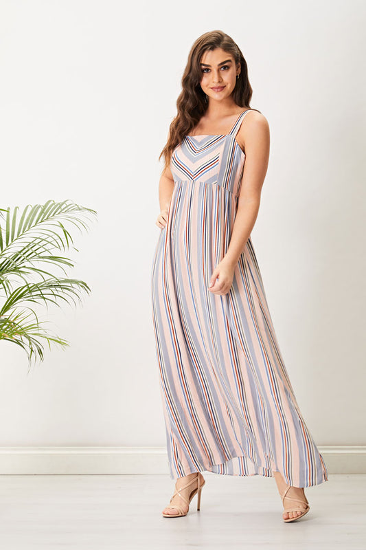 Brunette Haired Caucasian female wearing a Multi-color  Thick Spaghetti Strap  Flowy  Sleeveless  Square Neckline  Striped Patterned  Maxi Dress paired with cross strap open toed beige stilettoes 